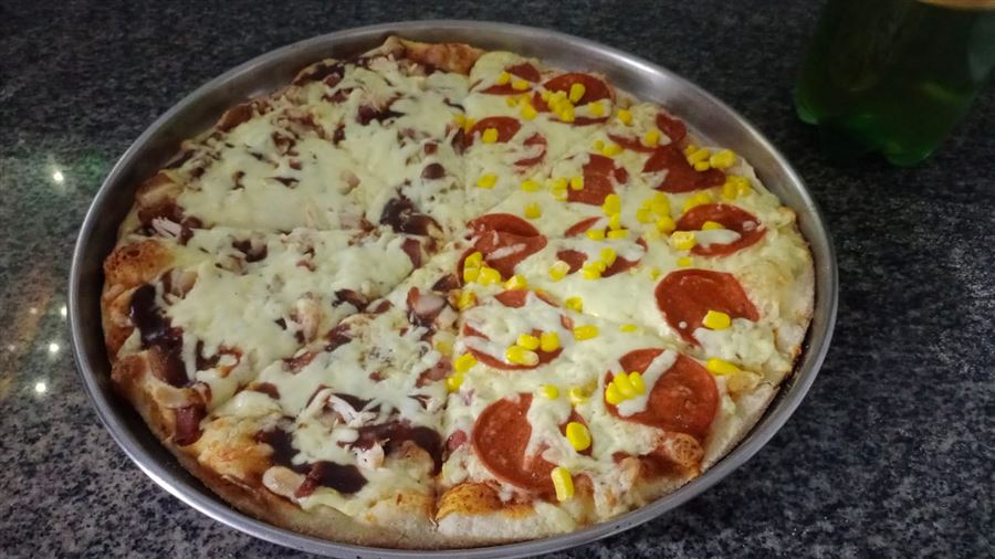Pizza mitad y mitad recién salida del horno